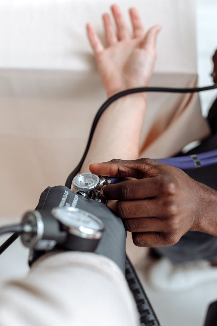 Close-up of a healthcare professional measuring a patient's blood pressure for a medical check-up.